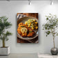 a large, appetizing plate of food, including a piece of fried chicken, potatoes, and a lemon slice, displayed on a wall.