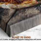 The image is a close-up of a pizza on a wooden surface, with a marble countertop visible in the background.