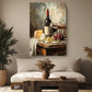 a cozy living room with a large painting of a table set with wine, cheese, and grapes hanging on the wall above a white sofa.