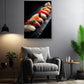 a modern living room with a gray armchair, a wooden side table, and a potted plant. Above the armchair, there is a framed photograph of sushi on a black surface.