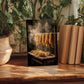 a wooden table with a framed photograph of noodles drying on a rack, surrounded by potted plants and books.