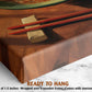 a wooden table with chopsticks resting on it, and there is a small piece of food on the table.