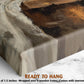 The image is a close-up of a wooden frame with a painting on top of it, and there is text that says "READY TO HANG" and "Depth of 1.5 inches - Wrapped over a wooden frame - Comes with sawtooth hanger".