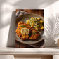 A plate of food, including a piece of fried meat and a side of potato salad, is displayed on a wooden surface.