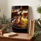 a wooden desk with a framed photograph of sausages and sauerkraut on a plate, surrounded by potted plants and books.