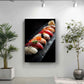 a framed photograph of a sushi dish on a black surface, with a variety of colorful sushi rolls and ingredients arranged in a visually appealing manner.